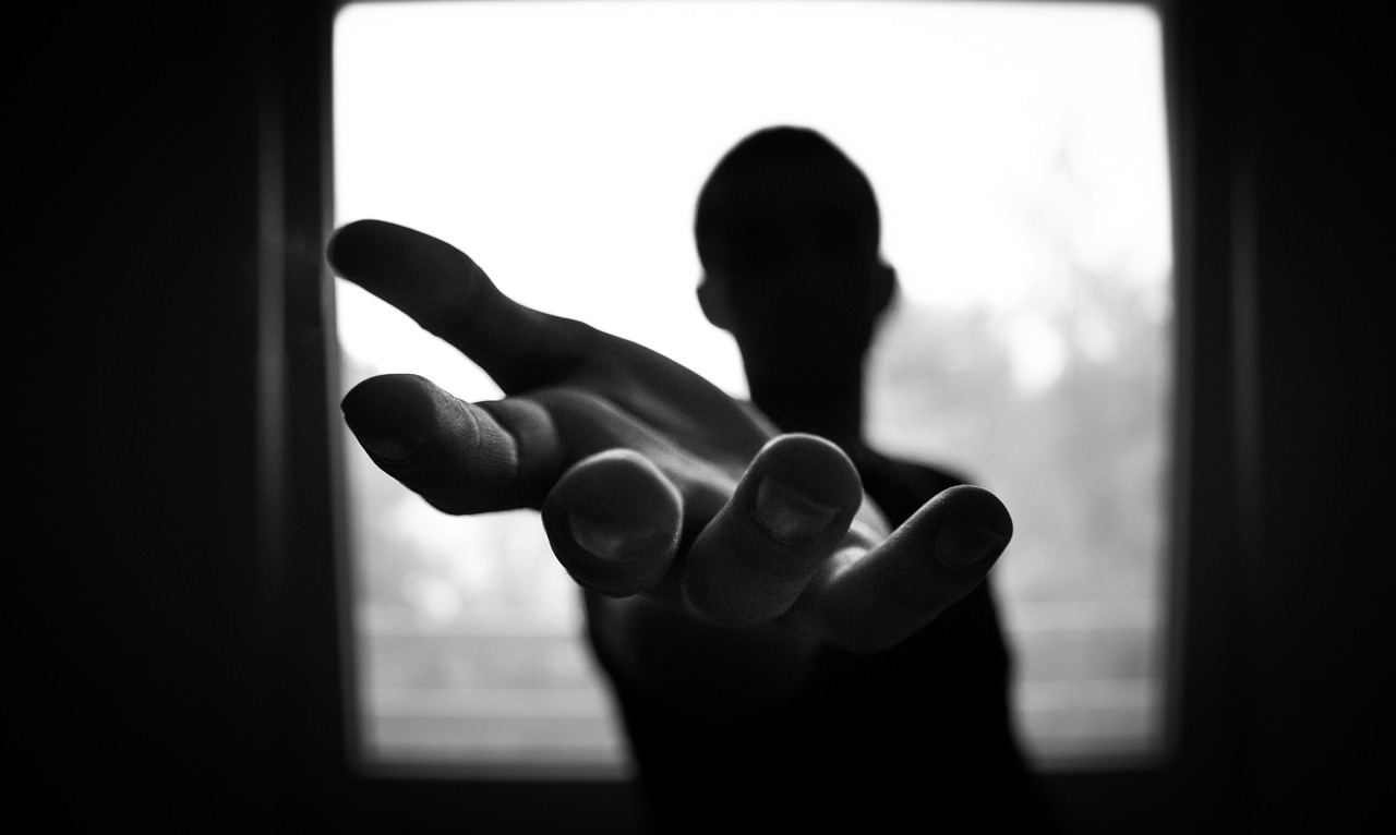 Eine Hand, die einer anderen Hand entgegenstreckt, symbolisiert Hilfe und Unterstützung